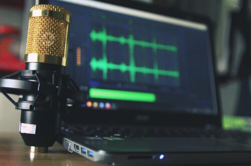 gold condenser microphone near laptop computer